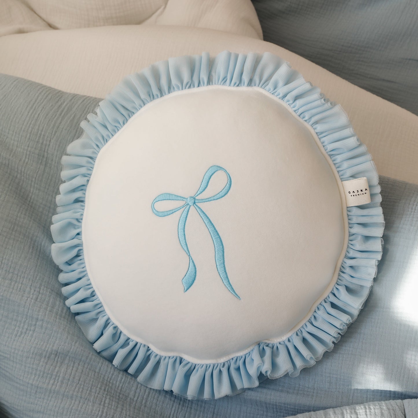 Round cushion with bow embroidery and ruffles